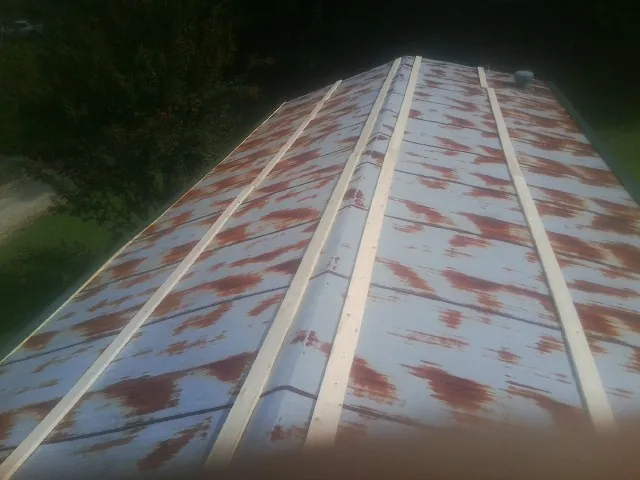 Rusted metal roof panels with new wood purlins before replacement — Storm Damage Roof Repair in Etoile by Roofing Brothers